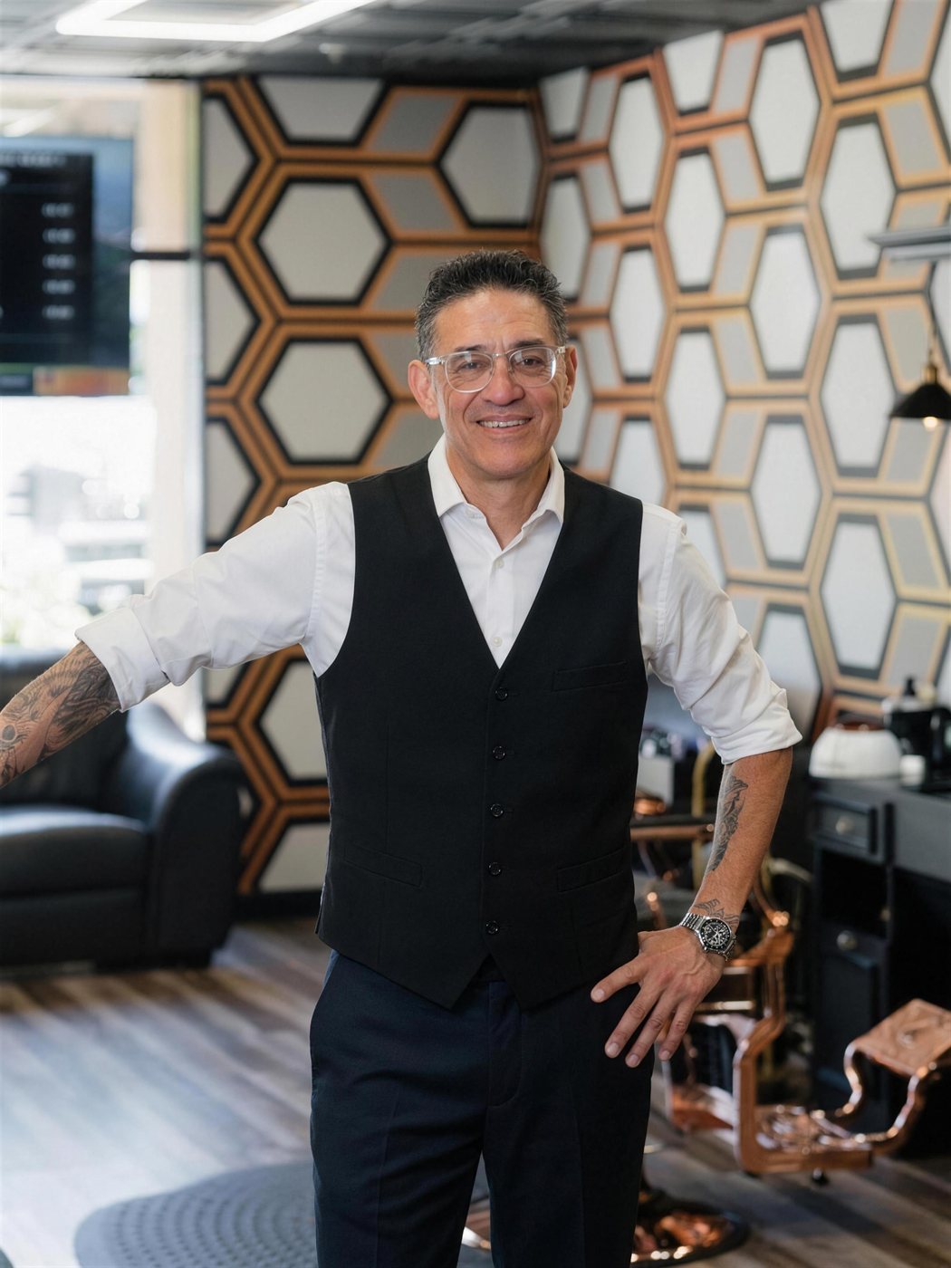 Master barber David Gonzales in a black vest and white shirt at Fathers Barber Salon