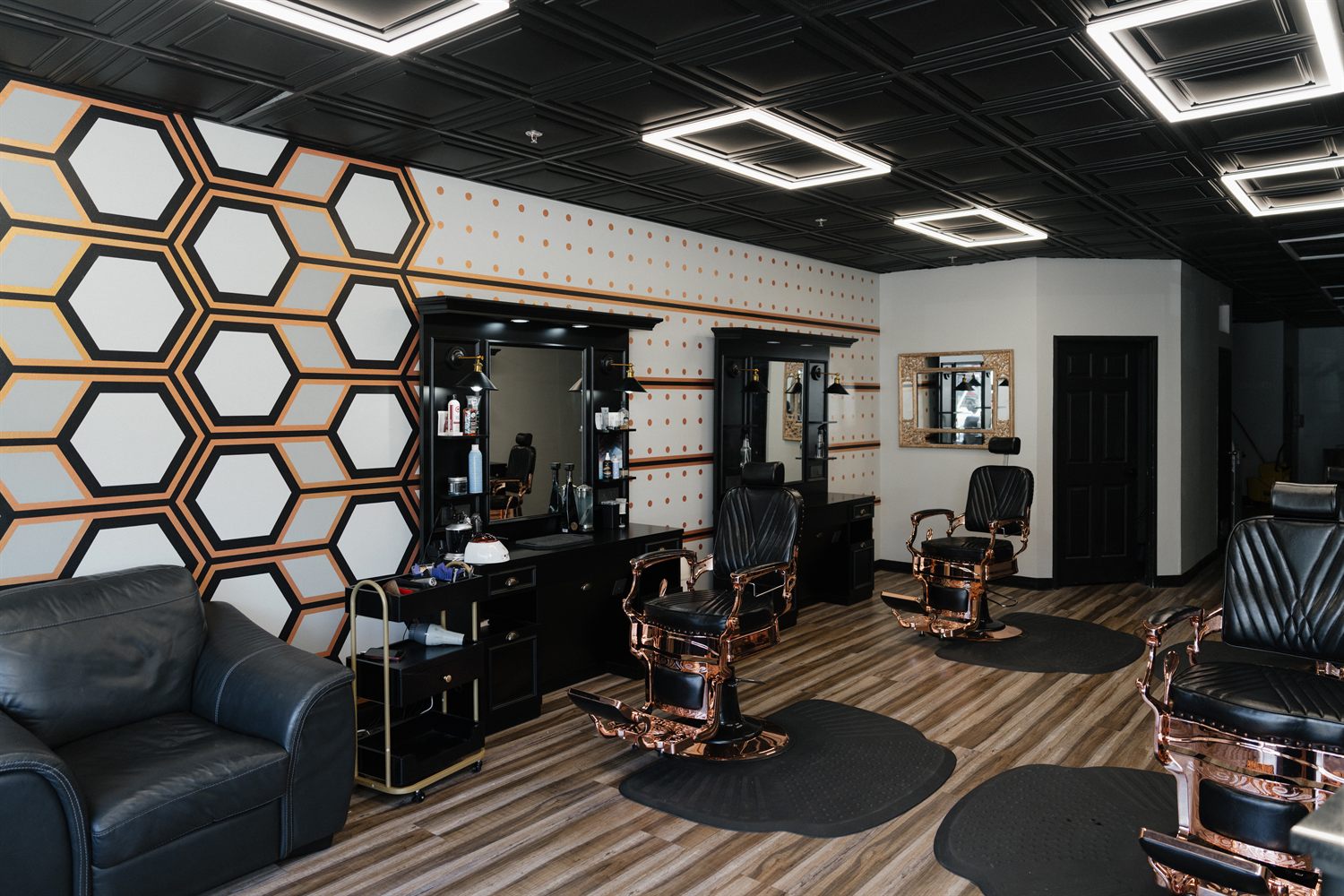 Fathers Barber Salon interior with leather lounge, rose-gold chairs and honeycomb wall