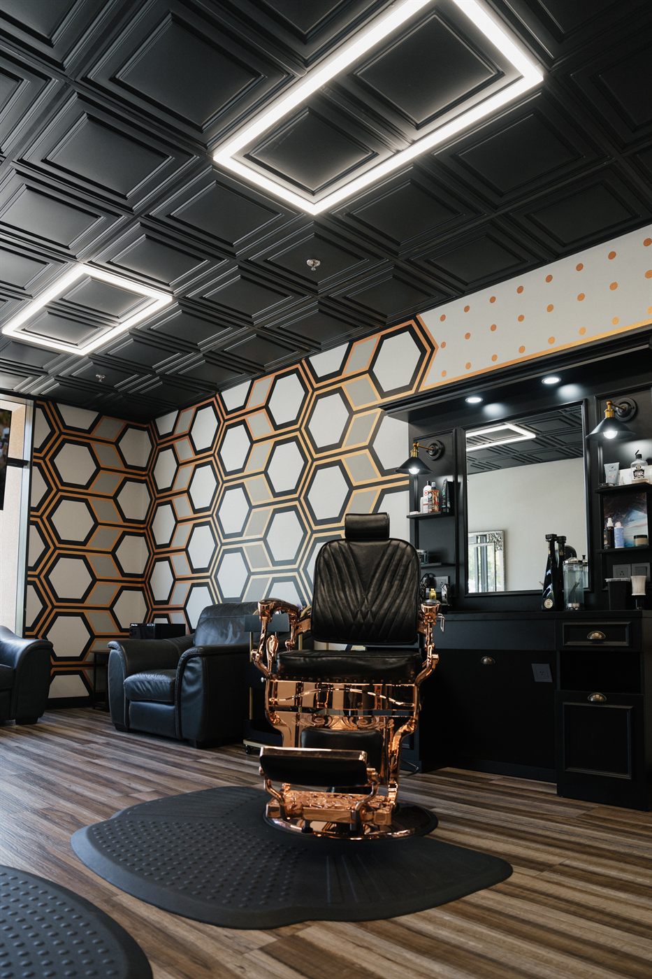 Rose-gold barber chair at a black mirror station