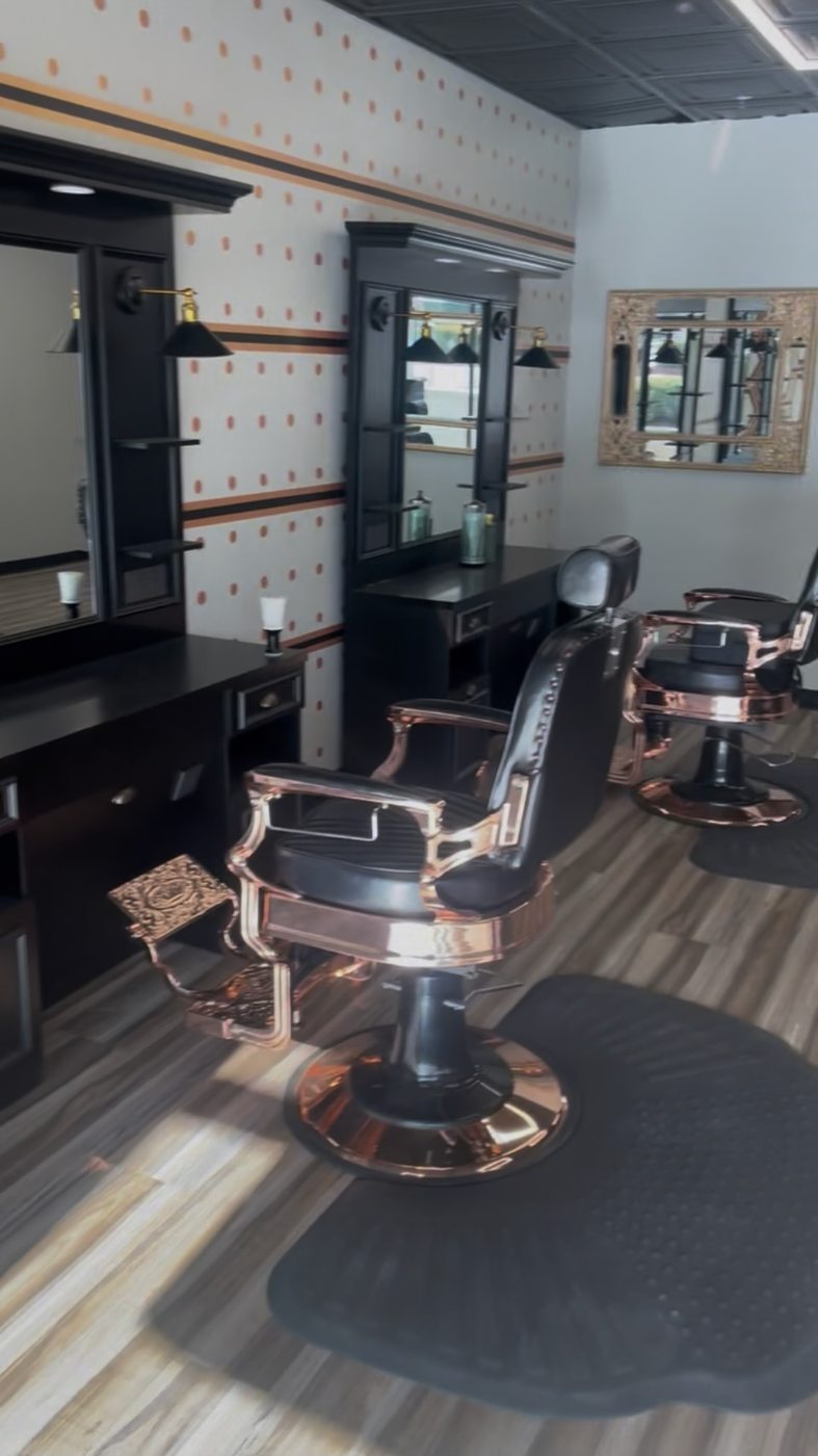 Two rose-gold barber chairs and stations inside Fathers Barber Salon